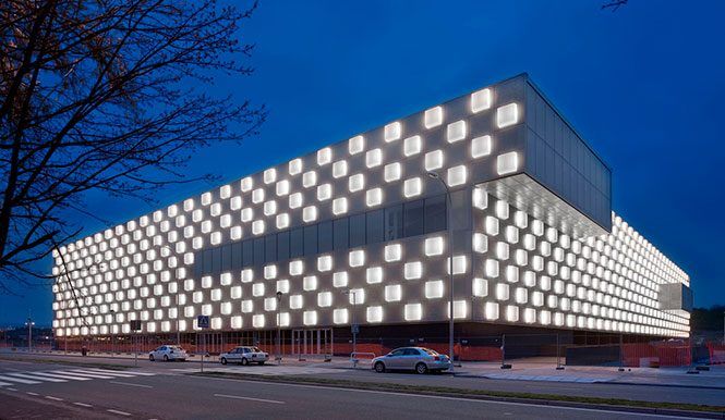 Fachada iluminada de un pabellón al anochecer